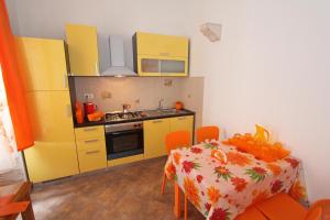 een kleine keuken met een tafel en gele kasten bij Villa Istria in Lovran