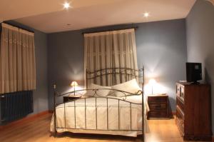 a bedroom with a bed and a dresser at Hotel Venta Magullo in La Lastrilla