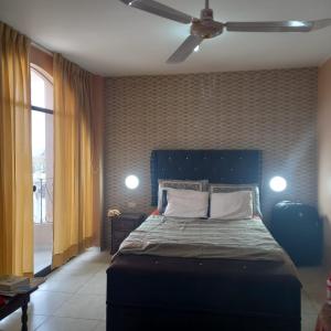 a bedroom with a bed and a ceiling fan at Hostal Luren in Nazca