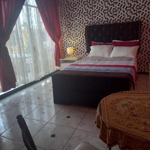 1 dormitorio con cama y ventana grande en Hostal Luren en Nazca