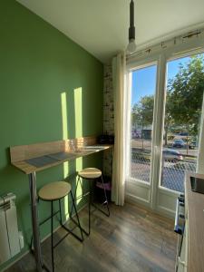 a kitchen with a counter and stools and a window at L’havrais détente in Le Havre