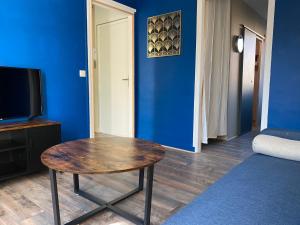 a room with a table and a blue wall at L’havrais détente in Le Havre