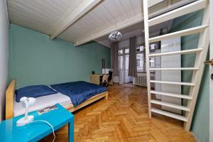 a bedroom with a bed and a desk and a ladder at Apartments Vorsilska in Prague
