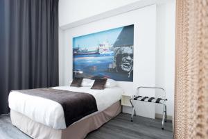 - une chambre avec un lit et une peinture murale dans l'établissement Hôtel François 1er, à La Rochelle