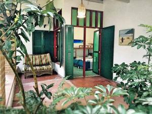 een woonkamer met groene deuren en een bank bij Pousada São Francisco in Cumuruxatiba