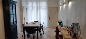 een eetkamer met een houten tafel en stoelen bij La maison de Marie, maison de ville 4 personnes, option chambre patio 2 pers supp in Aigues-Mortes