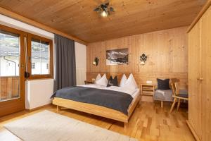 1 dormitorio con 1 cama grande en una habitación con paredes de madera en Haus Jochler, en Ried im Zillertal