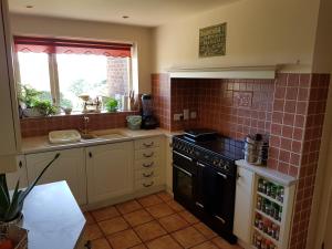 a kitchen with a stove and a sink and a window at Luxury Endon House Share in Endon