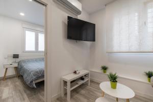 um quarto com uma cama e uma televisão de ecrã plano na parede em 4Torres Homes - Sofía em Madri