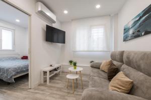 uma sala de estar com um sofá e uma cama em 4Torres Homes - Sofía em Madrid