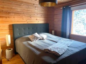 ein Schlafzimmer mit einem Bett in einem Blockhaus in der Unterkunft Iken Mökit in Heinola