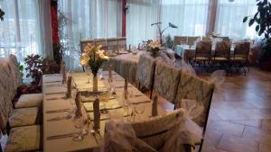 a long table in a room with chairs and a table with flowers at COMPLEX HARMONY/КОМПЛЕКС ХАРМОНИЯ in Tryavna