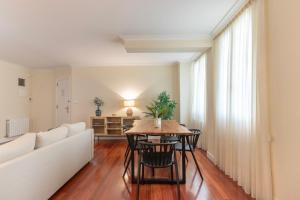 ein Wohnzimmer mit einem Tisch und einem Sofa in der Unterkunft AkomodaT en apartamento en el centro de Bilbao con parking in Bilbao