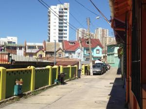 a street with houses and cars parked on the sidewalk at Barros Borgoño 1 Departamento in Valparaíso