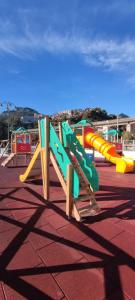 a playground with a colorful slide on a roof at Castagna Apartment Letojanni - Taormina in Letojanni