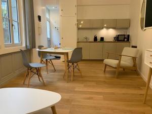 a living room with a table and chairs and a kitchen at Les Tiercelines in Dole