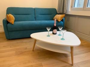 a living room with a couch and a table with wine glasses at Les Tiercelines in Dole