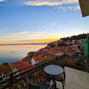 een tafel en stoelen op een balkon met uitzicht op de stad bij PS Apartments in Ohrid