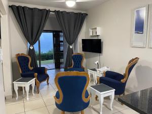 a living room with chairs and a table and a television at 3 Eden Sands in Kingsburgh