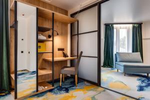 a room with a chair and a desk and a mirror at Optima Collection Mural Lviv in Lviv