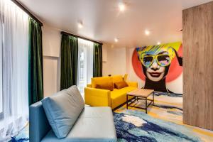 a living room with a yellow couch and a painting at Optima Collection Mural Lviv in Lviv +49 photos