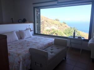 a bedroom with a large window with a bed and a chair at CASA LAS VISTAS in Fuencaliente de la Palma