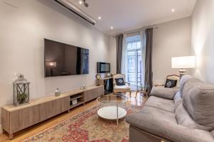 sala de estar con sofá y TV de pantalla plana en Amplio y Elegante en Casco Viejo con Parking, en Bilbao