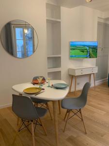 a dining room with a table and chairs and a mirror at Les Tiercelines in Dole
