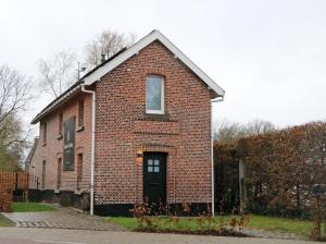 une vieille maison en briques avec une porte noire dans l'établissement Maison des Étoiles, à Aalst
