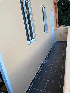 a room with a tiled floor and two windows at Habitación Independiente Zona Colonial in Santo Domingo