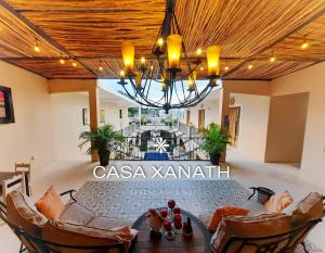ein Esszimmer mit Tisch, Stühlen und Kronleuchter in der Unterkunft Casa Xanath in Tulum