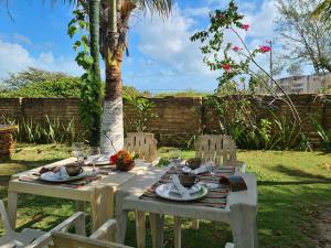 een tafel met borden voedsel erop in een tuin bij Villa Sirena Pousada de charme in Beberibe