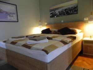 a bedroom with a large bed with towels on it at Apartments Katalenić in Selce