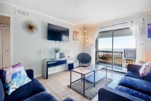 マートルビーチにあるCherry Grove Retreat & Sea Cabinの青いソファとテーブルのあるリビングルーム