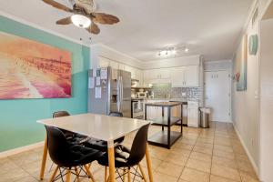 a kitchen with a table and a refrigerator at Cherry Grove Retreat & Sea Cabin in Myrtle Beach