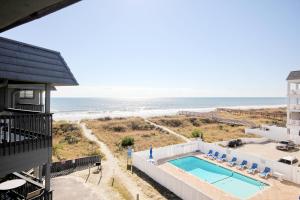 マートルビーチにあるCherry Grove Retreat & Sea Cabinのスイミングプールと海の景色を望めます。