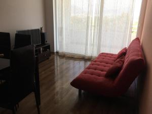 sala de estar con sofá rojo y TV en Condominio Terrazas del Sol, La Serena, en La Serena
