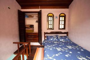 ein Schlafzimmer mit einem blauen Bett und einem Schrank in der Unterkunft Casa Maresias a 950m a pé da praia c churrasqueira in Maresias
