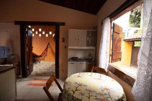 Zimmer mit einer Küche mit einem Tisch und einem Fenster in der Unterkunft Casa Maresias a 950m a pé da praia c churrasqueira in Maresias