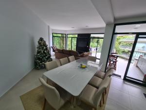 a dining room with a table and a christmas tree at Apartamento Ubatuba Reserva DNA in Ubatuba