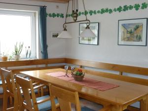 ein Esszimmer mit einem Holztisch und Stühlen in der Unterkunft Weingut-Brennerei-Gästehaus Emil Dauns in Reil