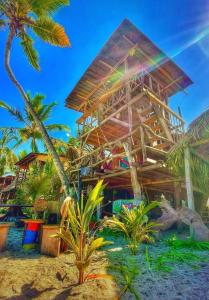 ein Resort am Strand mit Palmen davor in der Unterkunft Bob Marley Beach in Guachaca
