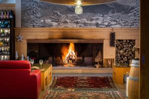 a living room with a fireplace and a red couch at Hotel Garni Pegrà in Ponte di Legno