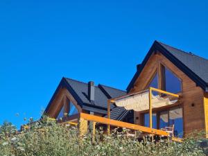 a house on a hill with a blue sky at Cortina resort in Ivanjica