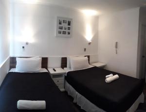 a hotel room with a white bed and white walls at Hotel Boutique Tremo Bellavista in Santiago