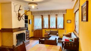 Casa Fresneda في Fresneda: غرفة معيشة بجدران صفراء ومدفأة