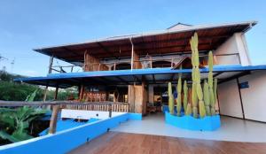 un bâtiment avec un toit bleu et de nombreuses planches de surf dans l'établissement Galápagos Casa Playa Mann, à Puerto Baquerizo Moreno