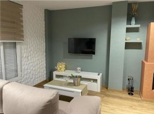 a living room with a couch and a tv on a wall at Loft Ben A Ocaz in Benaocaz