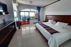 a bedroom with a large bed and a television at Galápagos Casa Playa Mann in Puerto Baquerizo Moreno