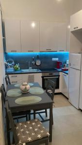 una cucina con tavolo, sedie e frigorifero di Chris AKROPOLI ad Atene